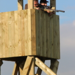 participants shooting a rifle at the top of a pirch during the Forest Games