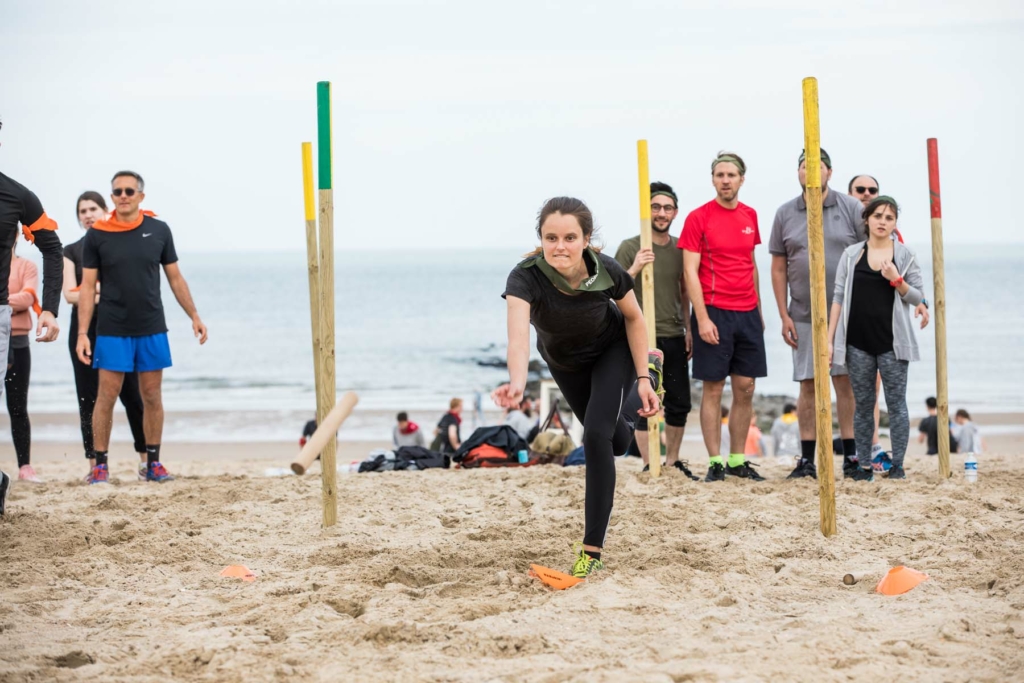 participant throwing a stick for her team during a Robinson's Quest challenge