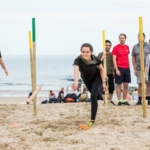 participant throwing a stick for her team during a Robinson's Quest challenge