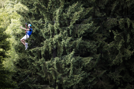 participant descendant un arbre en rappel lors d’un parcours aérien