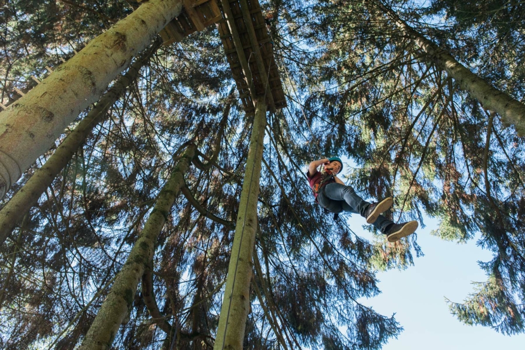 participant crossing a suspension bridge during an aerial course