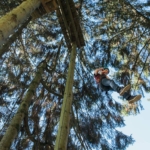 participant crossing a suspension bridge during an aerial course