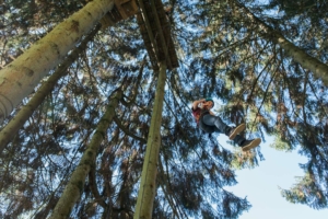 participant crossing a suspension bridge during an aerial course