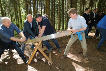 équipe sciant à la main un rondin de bois lors d’un Adventure Trail