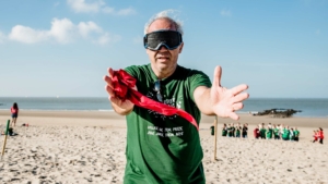 participants blindfolded and with open arms during the Beach Olympics