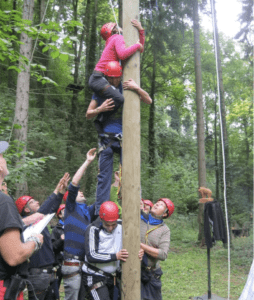 woman pulling herself up on a trunk during a boar game