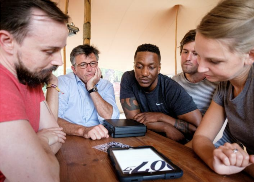 participants around a tablet performing a Bond Quiz during a Secret Agent School