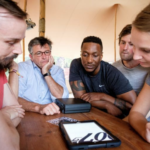 participants around a tablet performing a Bond Quiz during a Secret Agent School