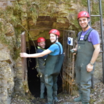 participants equipped with a helmet entering a cave in Lost