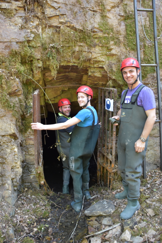 participants equipped with a helmet entering a cave in Lost