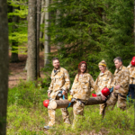 team carrying a tree trunk during the Step out of your comfort zone